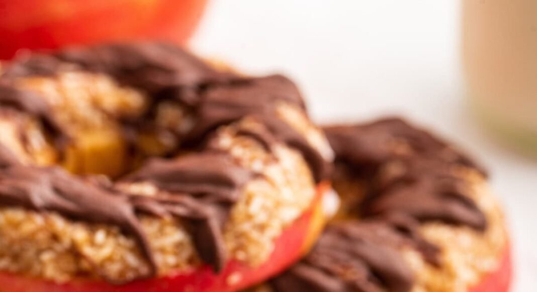 Multiple apple samoas near one another. The slices are topped with a chocolate drizzle.