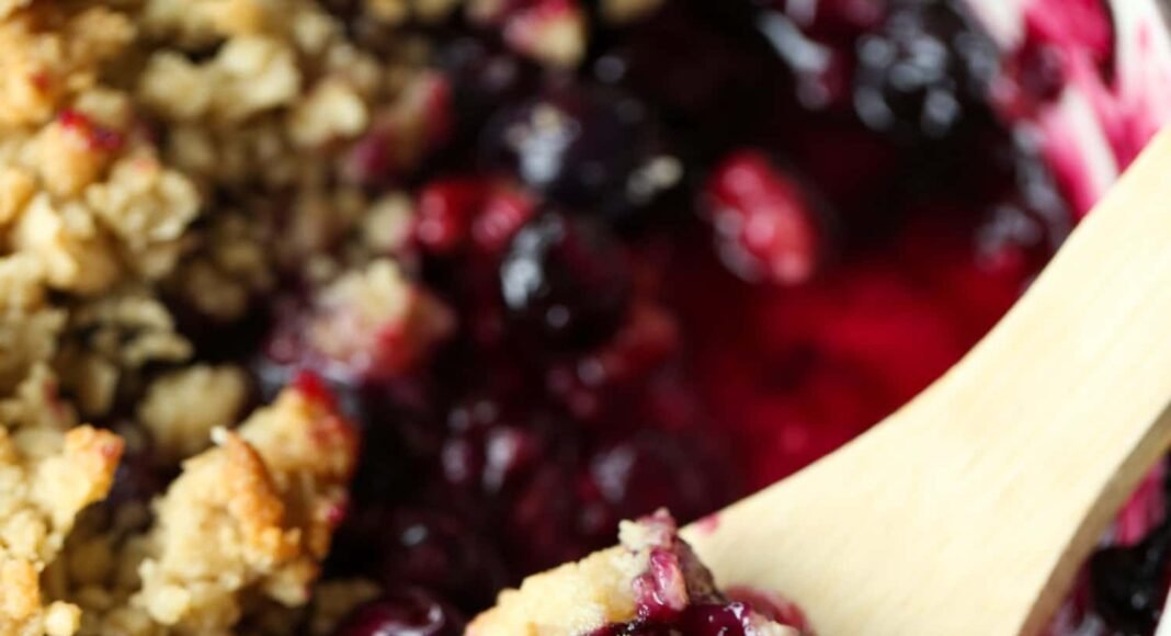 Blueberry Crisp in a baking dish with a spoon to serve