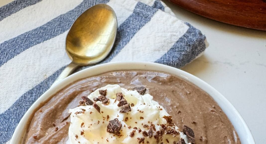 A small white bowl with chocolate pudding. There