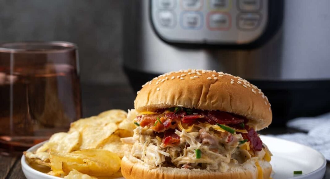 Landscape photo of a creamy crack chicken burger with bacon, cheddar, and chives.