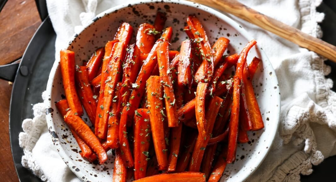 Sliced roasted carrots in a ceramic bowl from above garnished with parsley