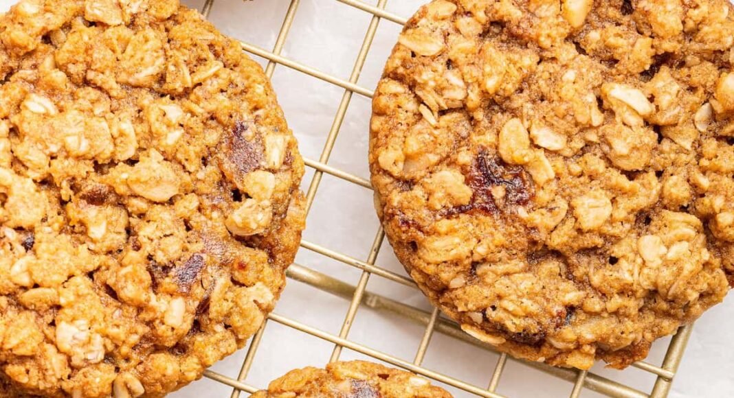Oatmeal date cookies on a gold wire cooling rack.