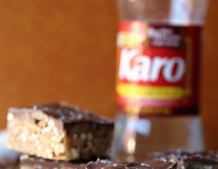 Sliced scotcheroos with a bottle of corn syrup in the background. 