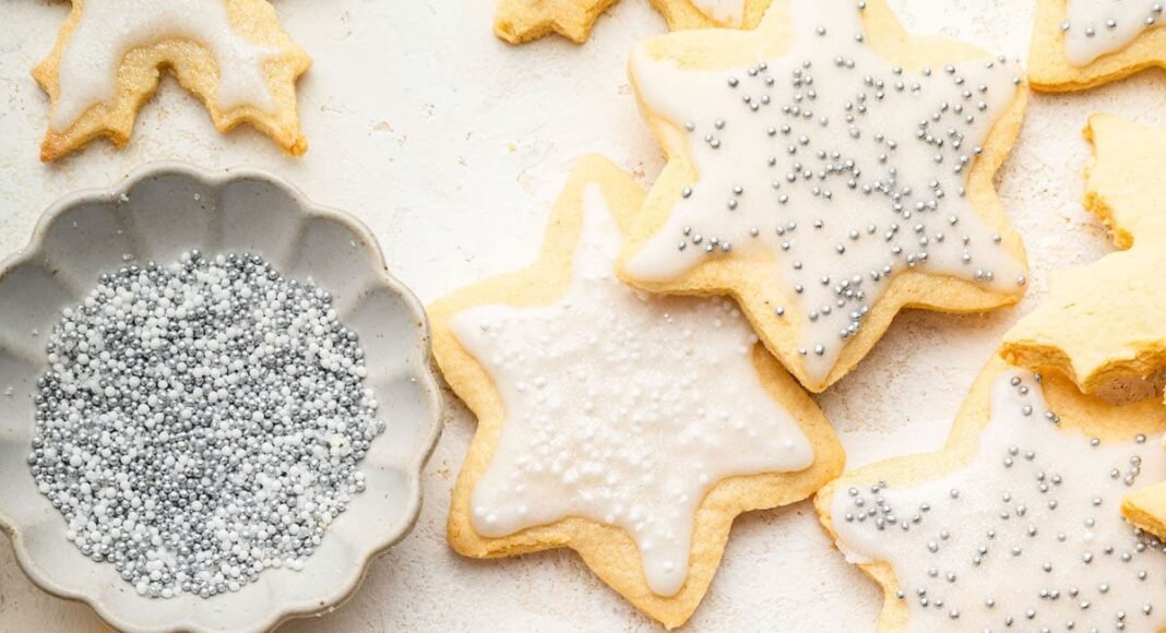 Multiple gluten free sugar cookies decorated with icing and sprinkles.