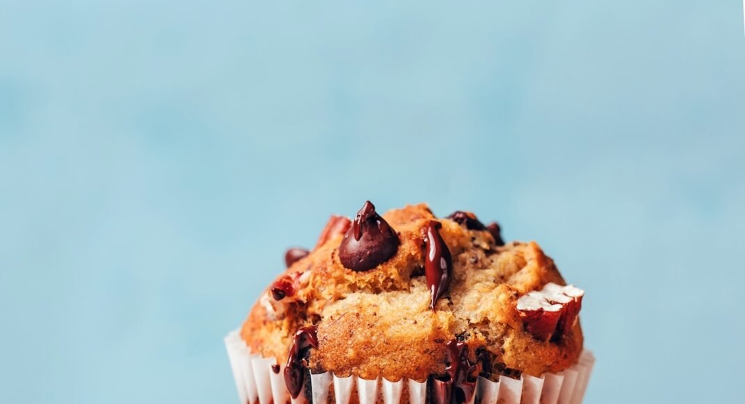 Stack of vegan gluten-free banana chocolate chip muffins dripping with melty chocolate