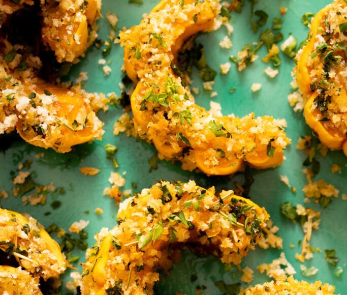 Close up photo of roasted delicata squash coated a garlic & herb breading