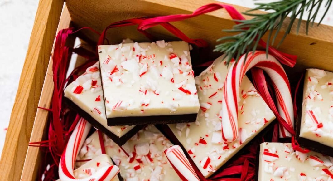 Square peppermint bark pieces stacked on top of each other in a gift box.