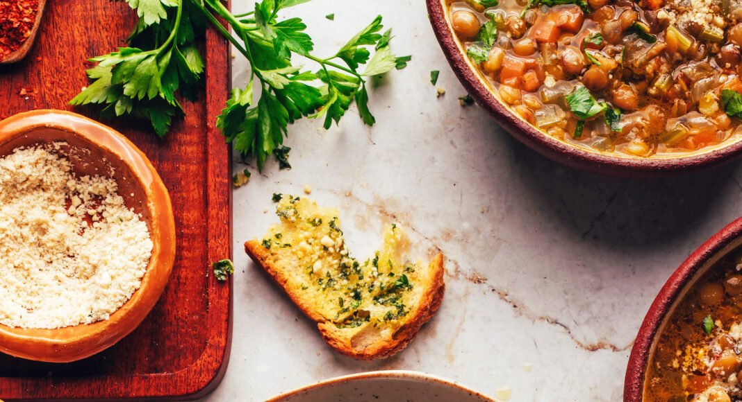 Bowls of Italian lentil soup with slices of garlic bread
