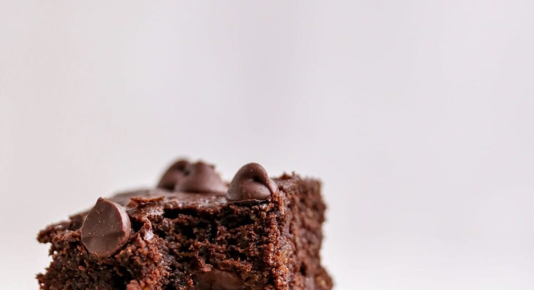 Three protein brownies stacked on top of one another. The top brownie has a bite taken out of it.