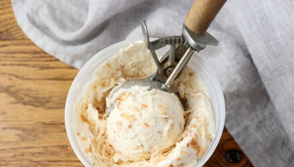 close up of coconut ice cream with wooden scoop