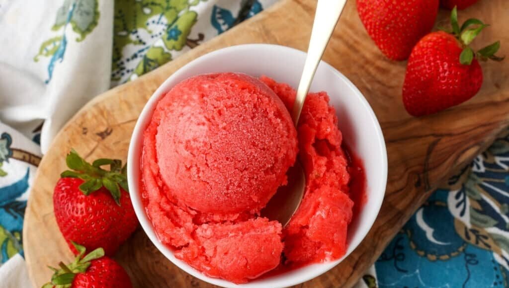 overhead shot of sorbet with strawberries on cutting board