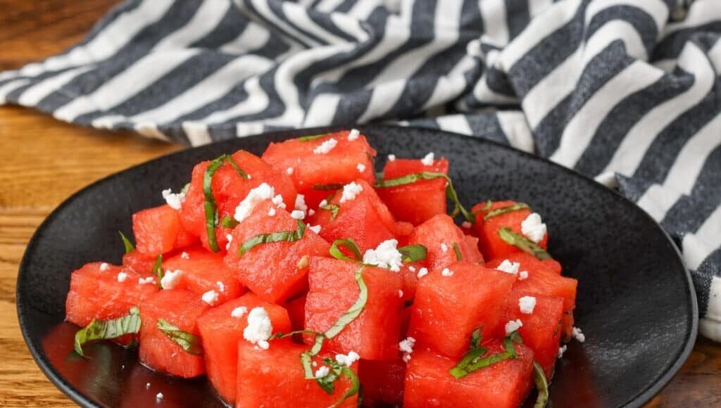 watermelon basil salad on a black plate