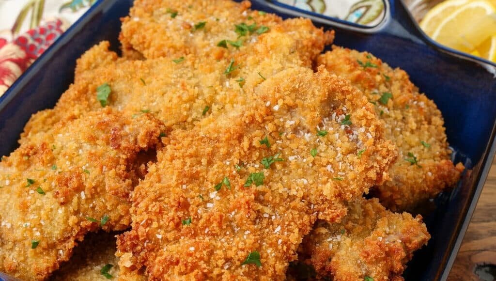 close up of fried pork cutlets in blue dish