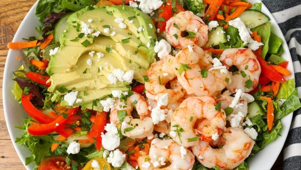salad with avocado and shrimp on white platter 