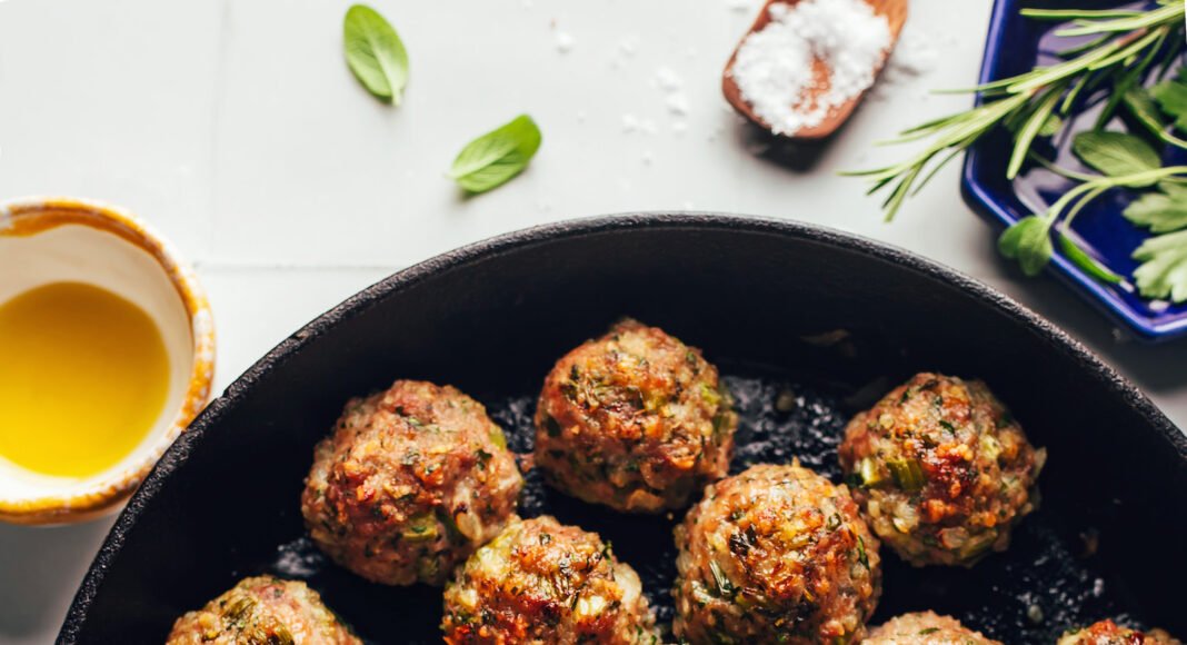 Cast iron skillet filled with a batch of perfectly browned Thanksgiving turkey meatballs